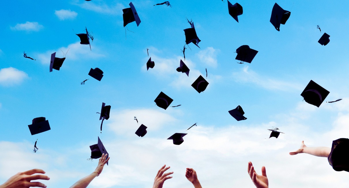 Toques de diplome lancees en l air devant un ciel bleu lors d une ceremonie de remise des diplomes