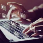 Mains sur clavier d ordinateur avec notifications et icones de reseaux sociaux