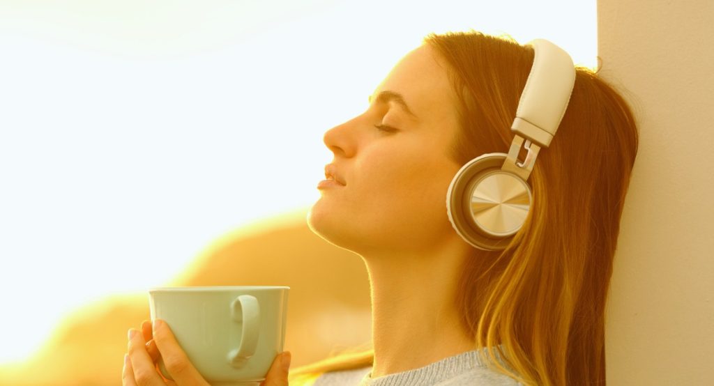 Femme avec casque audio les yeux fermes ecoutant de la musique en streaming